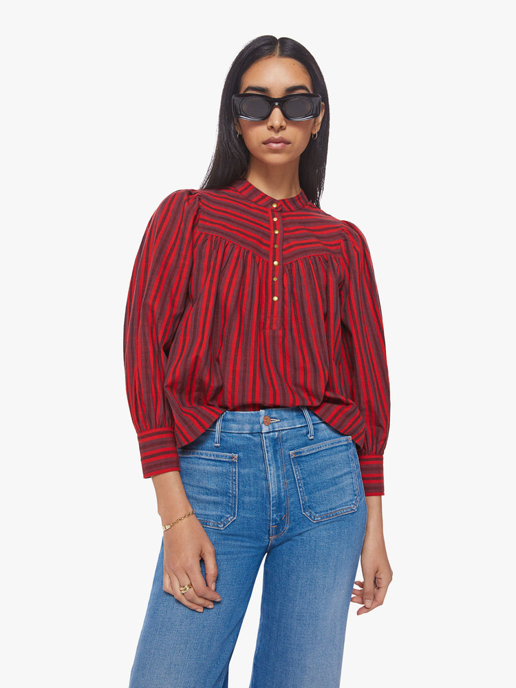 Front view of a women red, grey, black stripe pattern blouse with a buttoned V-neck, puffed 3/4-sleeves and a slightly cropped hem.  