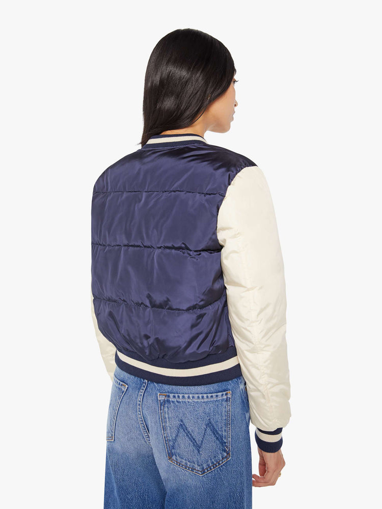 Back  view of navy quilted letterman jacket with a crewneck, snaps down the front, ribbed hems and a slightly cropped fit.