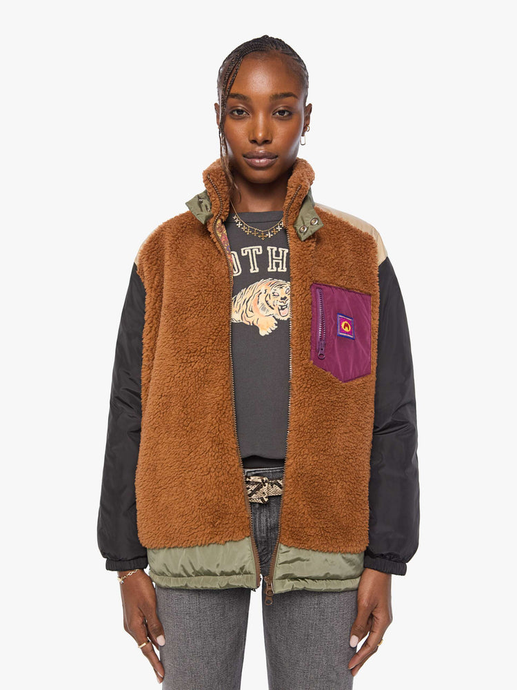 Front view of a woman in sherpa oversized jacket with a funnel neck, drop shoulders, a front patch pocket and zip closure.