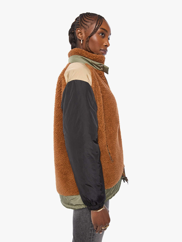 Side view of a woman in sherpa oversized jacket with a funnel neck, drop shoulders, a front patch pocket and zip closure.