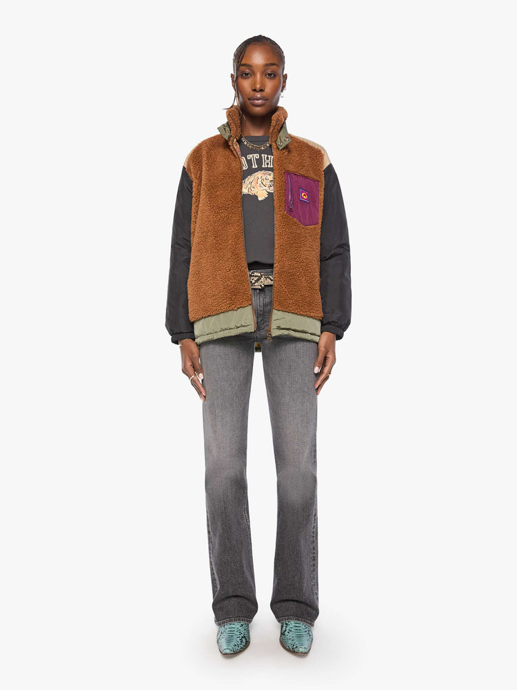 Full body view of a woman in sherpa oversized jacket with a funnel neck, drop shoulders, a front patch pocket and zip closure.