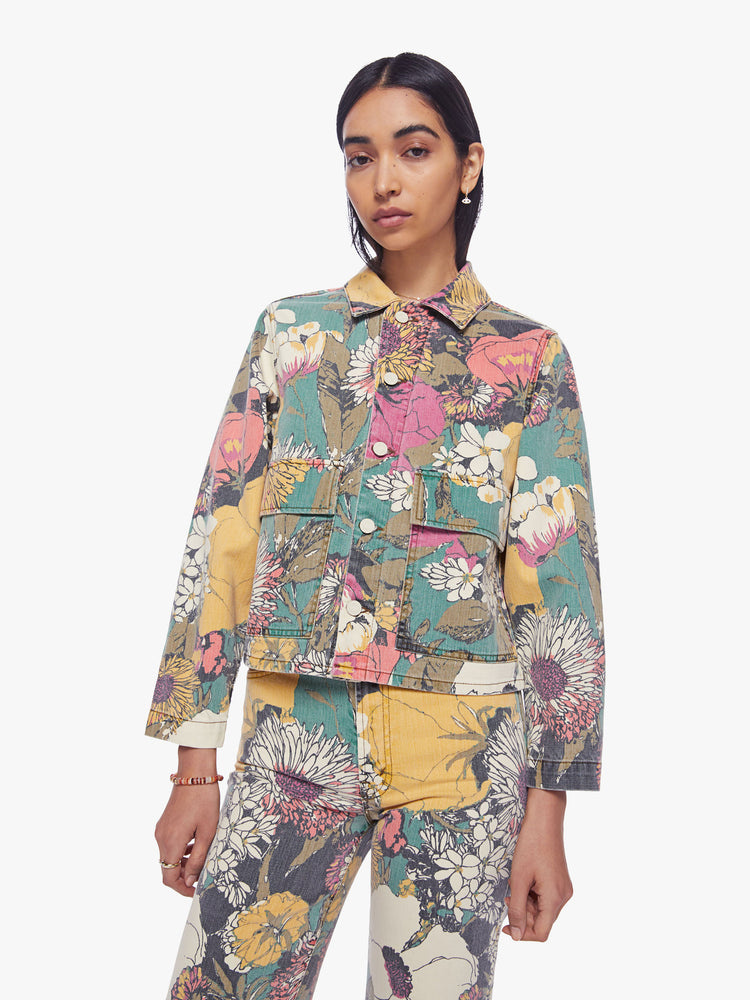 Front view of a woman faded floral print denim jacket with oversized front patch pockets, cropped long sleeves and a boxy, shrunken fit.