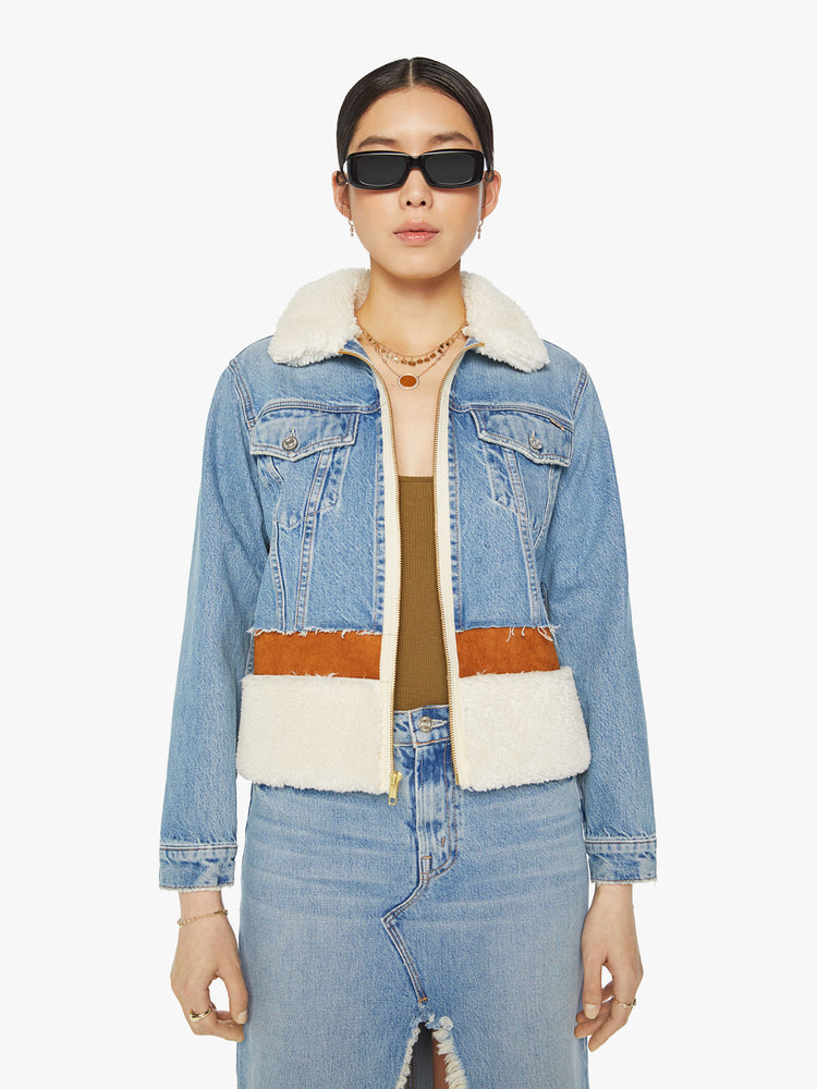 Front view of a woman  zip-up denim jacket with front patch pockets and a slightly cropped fit in a light blue wash with faux suede panels and sherpa trim.