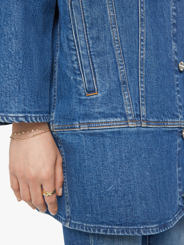 Swatch view of a woman elongated denim jacket with drop shoulders, boxy wing sleeves and a curved, thigh-length hem in classic blue wash.