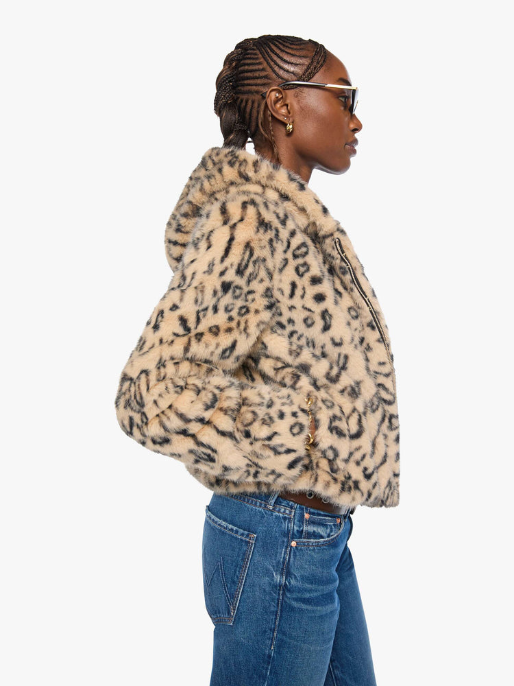 Side view of a woman in a light tan and black cheetah print zip-up hooded jacket with a slightly cropped fit.