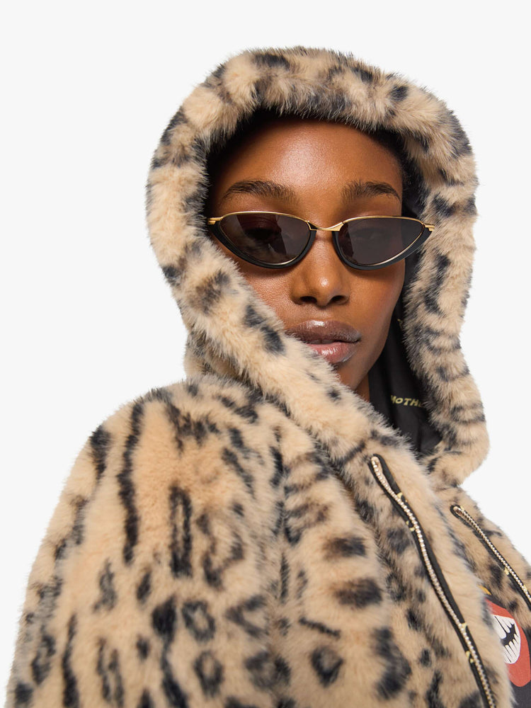 Close up view of a woman in a light tan and black cheetah print zip-up hooded jacket with a slightly cropped fit.