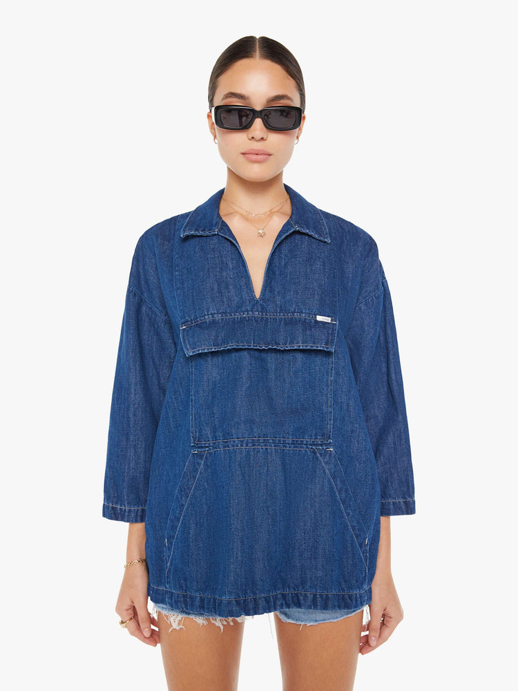 Front view of a womens dark blue denim jacket poncho featuring an open collar neck, cropped sleeves, and a front kangaroo pocket.