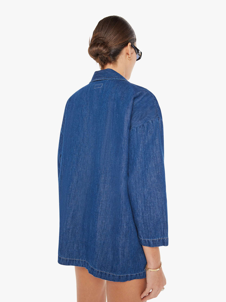 Back view of a womens dark blue denim jacket poncho featuring an open collar neck and cropped sleeves.