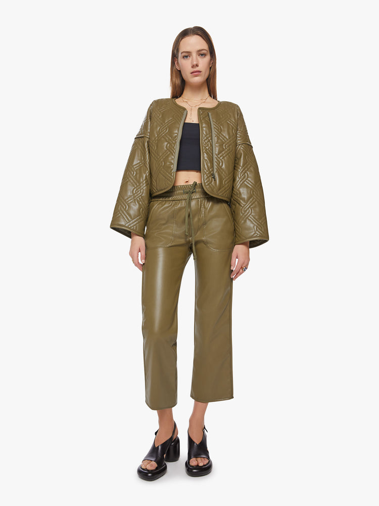 Full body view of a womans fir green hue faux leather boxy zip-up jacket with drop shoulders, extra-wide long sleeves and a cropped hem.