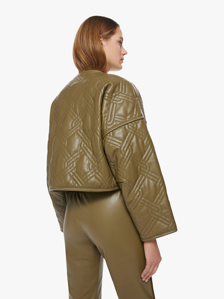 Back view of a womans fir green hue faux leather boxy zip-up jacket with drop shoulders, extra-wide long sleeves and a cropped hem.