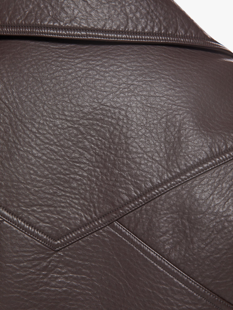 Swatch view of a woman brown faux leather jacket with a dramatically oversized collar, front slit pockets, drop shoulders and a hidden zip closure with buttons down the front.