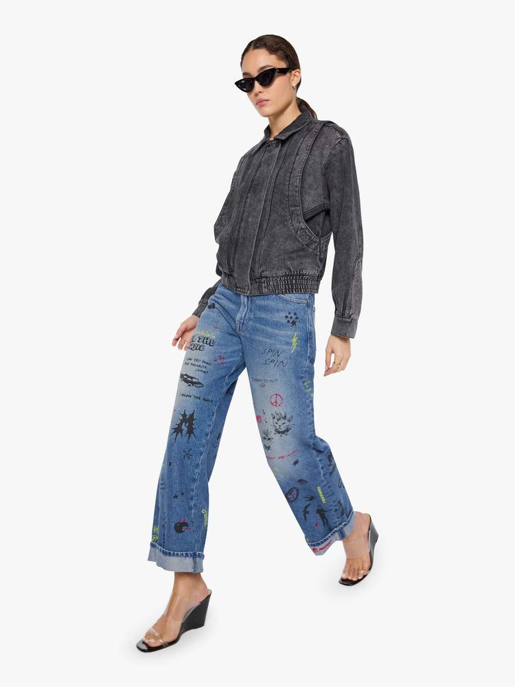Walking view of a woman in a faded grey  jacket is designed with drop shoulders, seamed details, hidden Velcro pockets, an elastic hem and a zip closure with a button flap. 