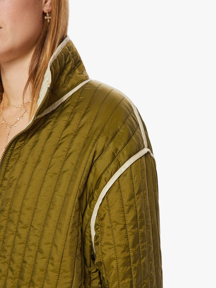 Close up  view of a woman reversible zip-up jacket with drop shoulders, patch pockets and a boxy fit, army green on one side and cream on the other with angsty doodles in black.