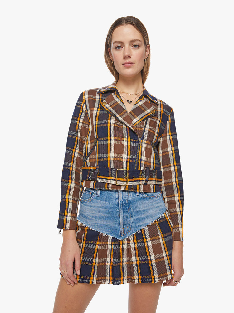 Front view of a woman cropped moto jacket with a notched collar, zip pockets and a belted waistband in a navy, orange and brown plaid with brass-toned hardware.