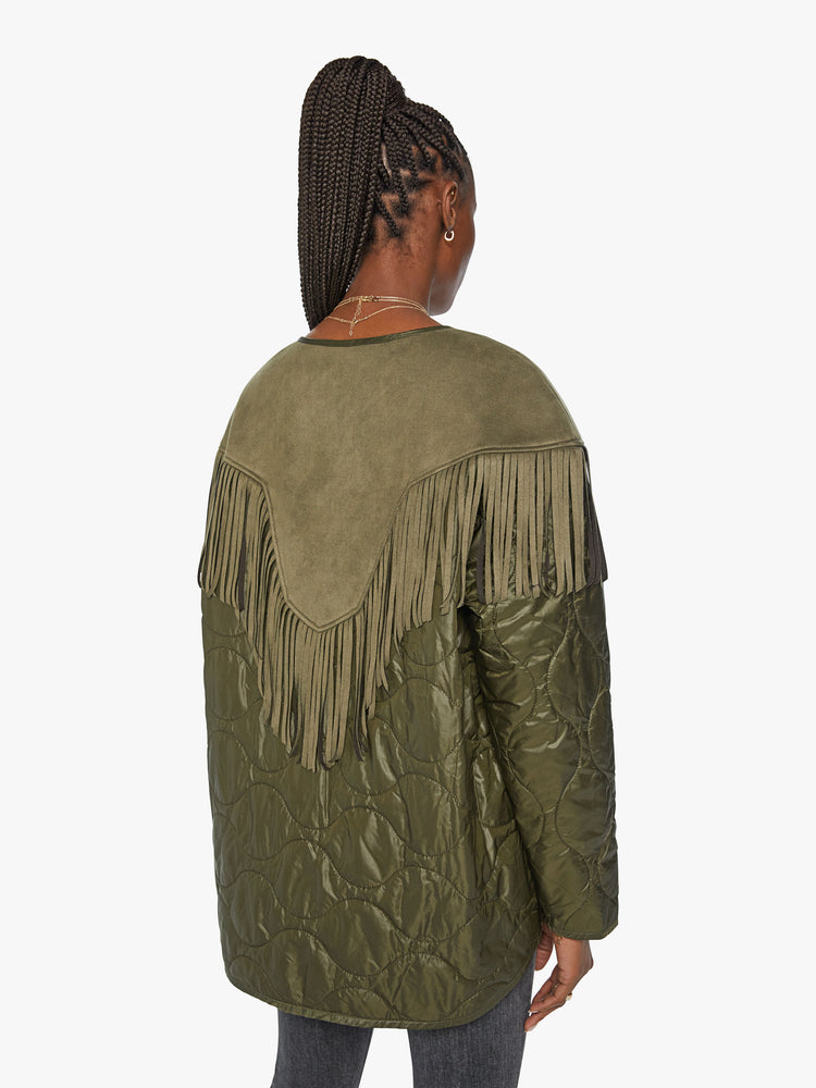 Back view of a woman with military liner jacket with a Western-inspired yoke, fringe trim and oversized patch pockets in an army green with faux-suede details.