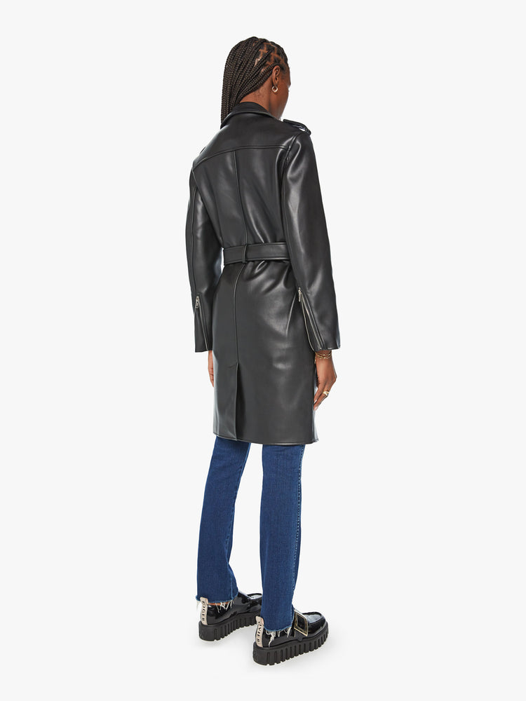 Back view of woman black motorcycle trench coat with a notched collar, belted waist, zip closure and a thigh-grazing hem.