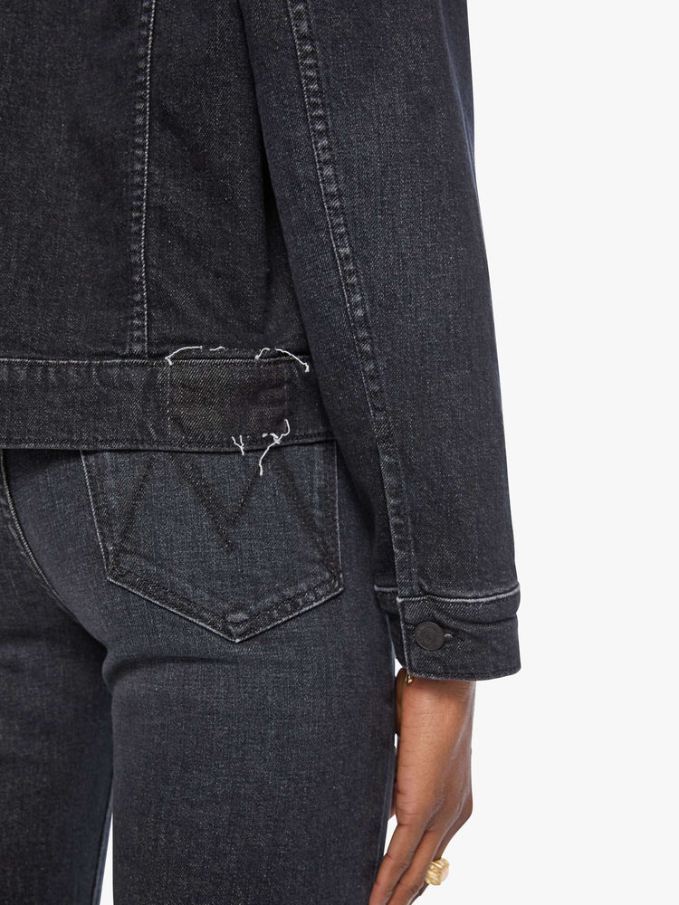 Close up view of a woman in  a washed classic denim jacket with front patch pockets and a slightly cropped fit. 