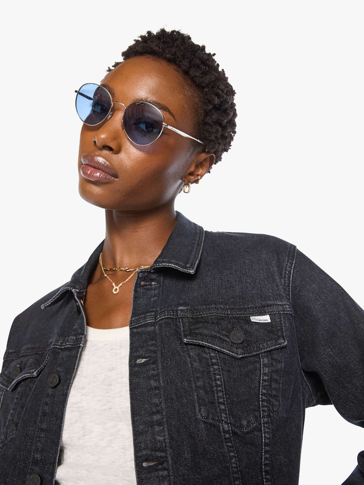 Close up view of a woman in  a washed classic denim jacket with front patch pockets and a slightly cropped fit. 