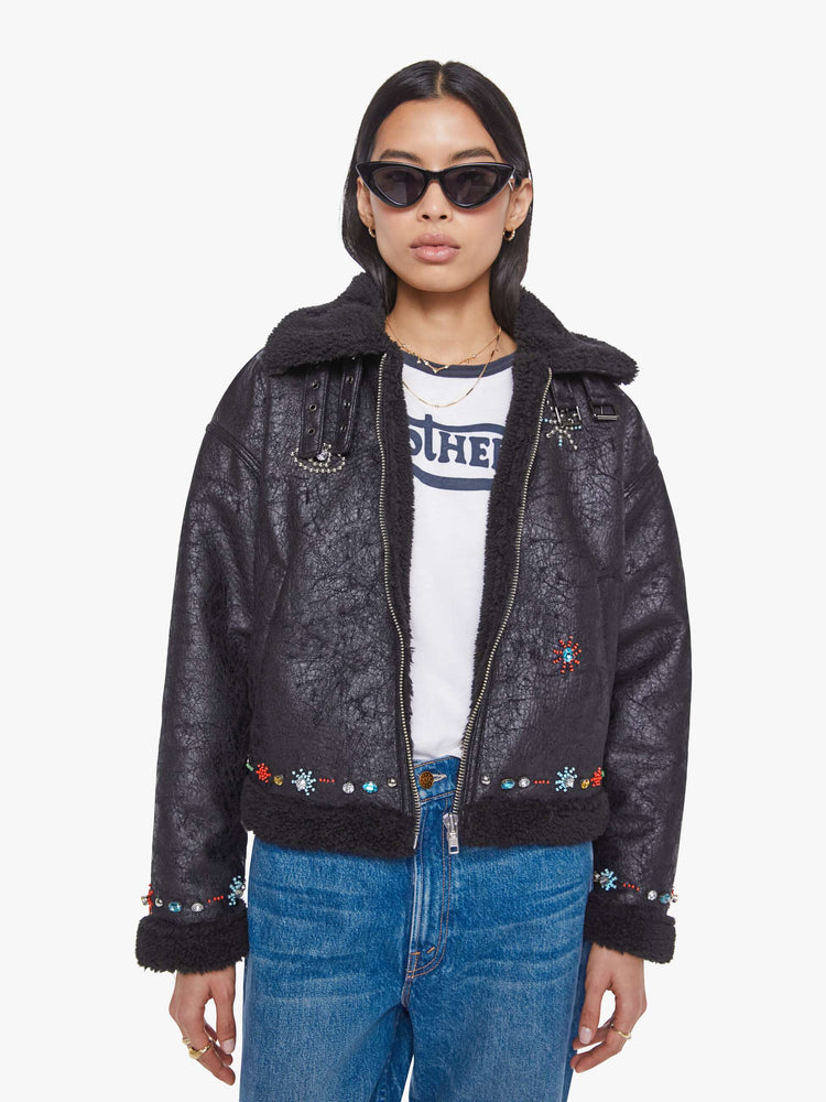 Front view of a woman in metallic black collared zip-up jacket with drop shoulders and a slightly cropped, boxy fit.