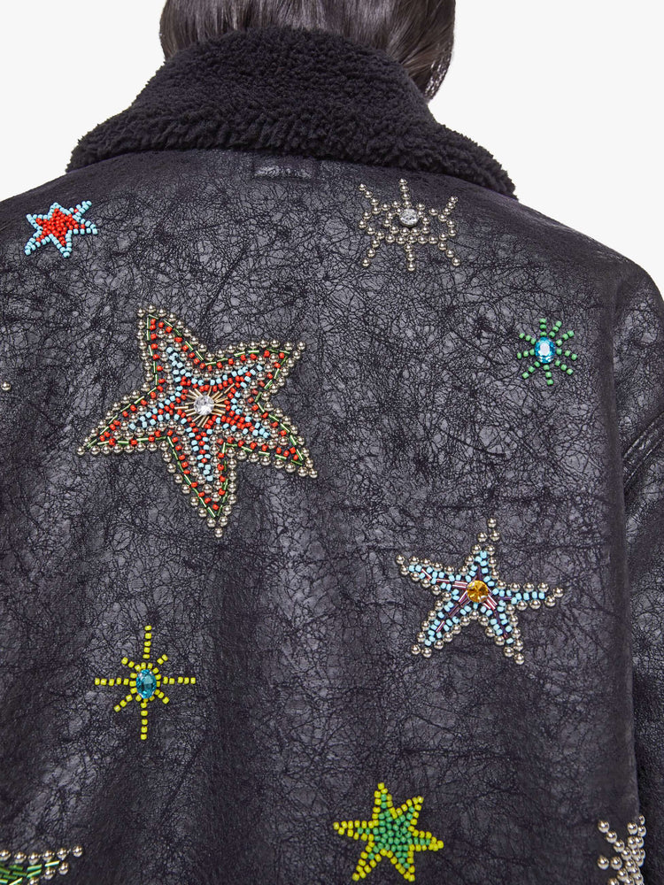 Close up view of a woman in metallic black collared zip-up jacket with drop shoulders and a slightly cropped, boxy fit.