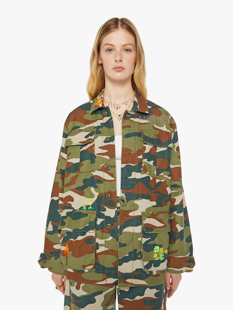 Front view of a woman in an army jacket with  oversized patch pockets, slightly dropped shoulders, buttons down the front and an oversized fit. 