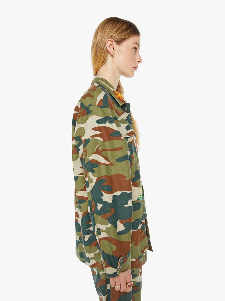 Side view of a woman in an army jacket with  oversized patch pockets, slightly dropped shoulders, buttons down the front and an oversized fit. 