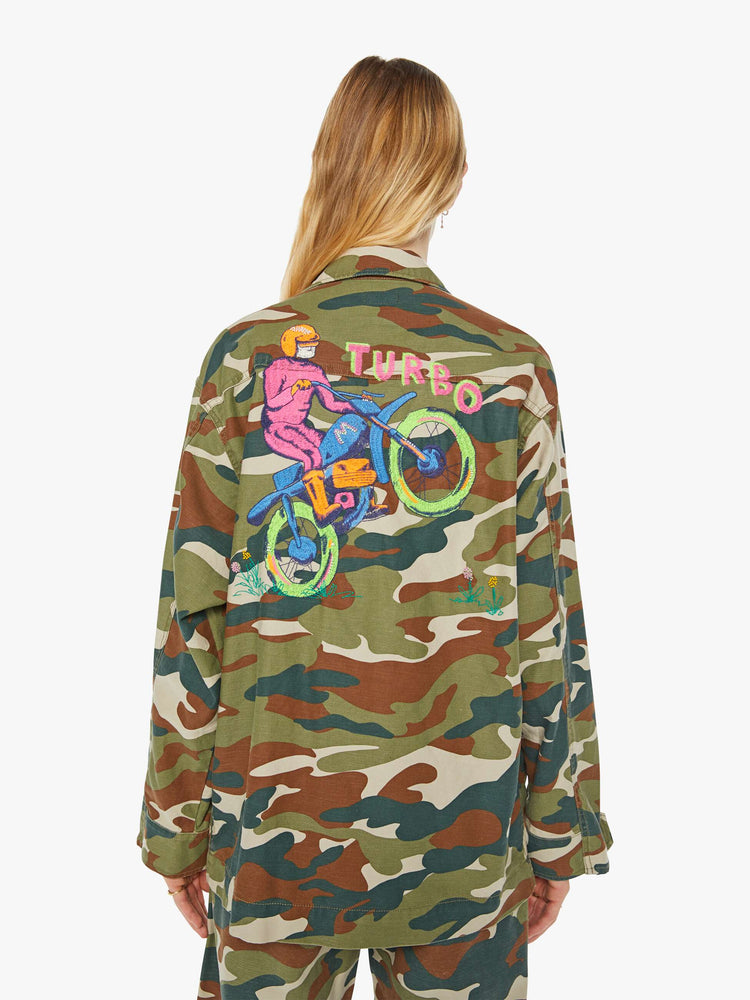 Back view of a woman in an army jacket with  oversized patch pockets, slightly dropped shoulders, buttons down the front and an oversized fit. 