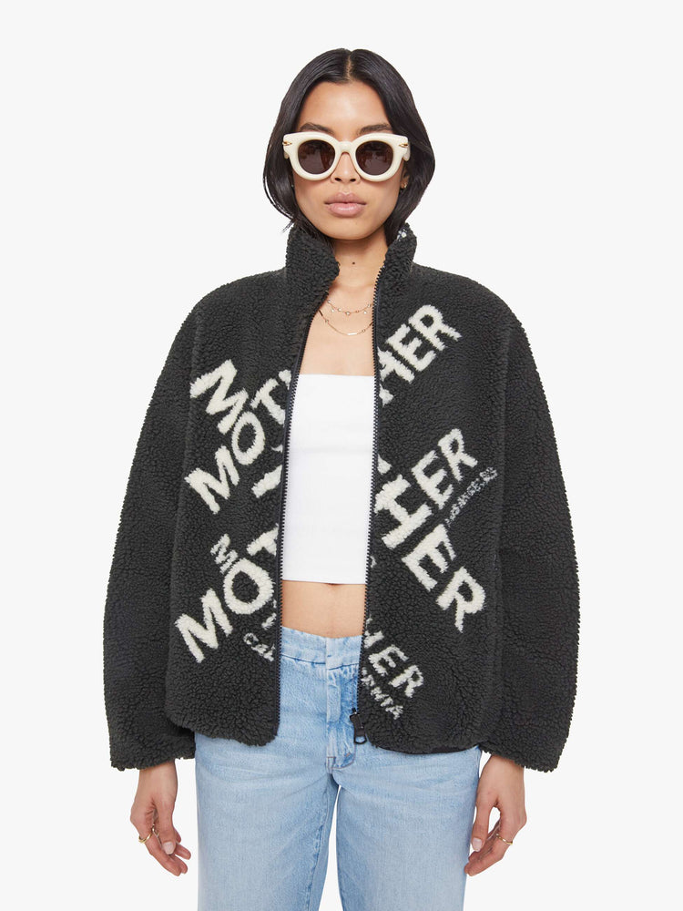 Front view of a woman in a reversible fleece jacket with a stacked collar, zip closure, patch pocket at the chest, slightly dropped shoulders and a loose fit.