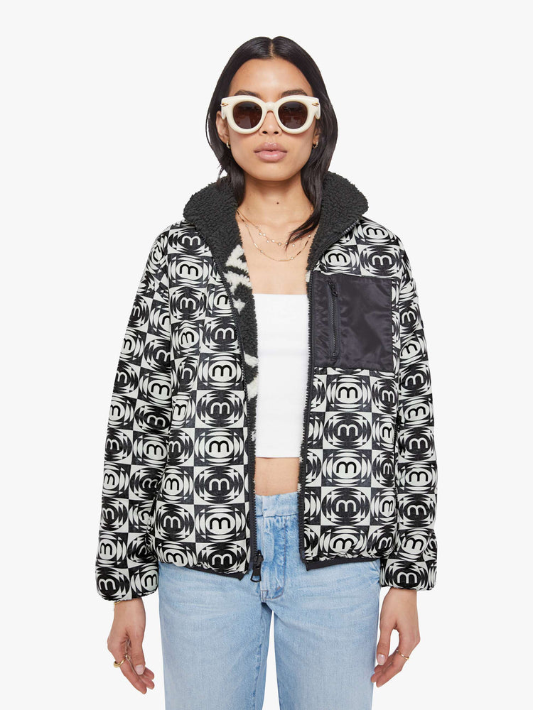 Front view of a woman in a reversible fleece jacket with a stacked collar, zip closure, patch pocket at the chest, slightly dropped shoulders and a loose fit.