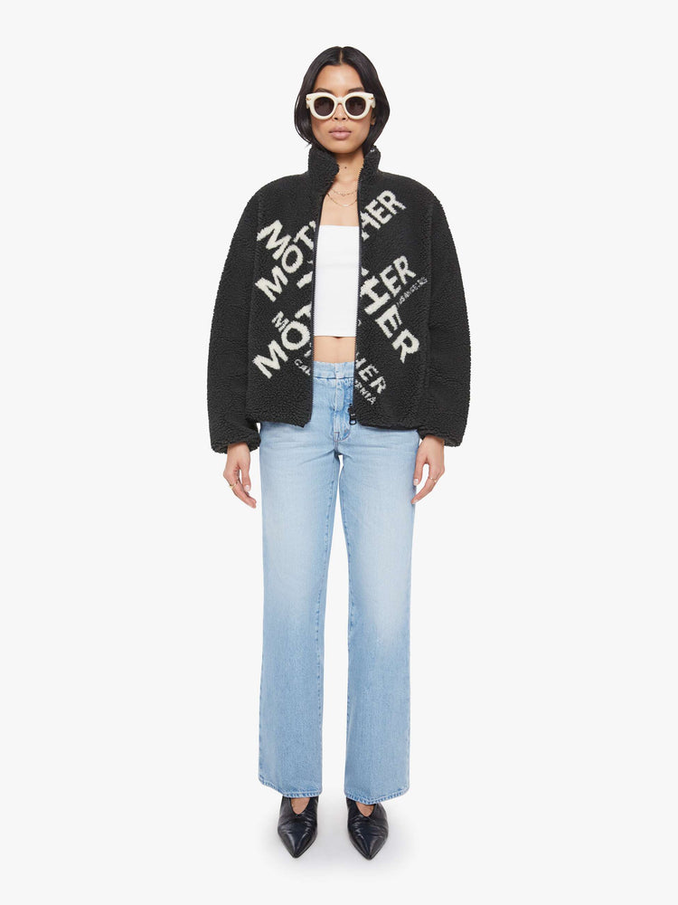 Full body view of a woman in a reversible fleece jacket with a stacked collar, zip closure, patch pocket at the chest, slightly dropped shoulders and a loose fit.