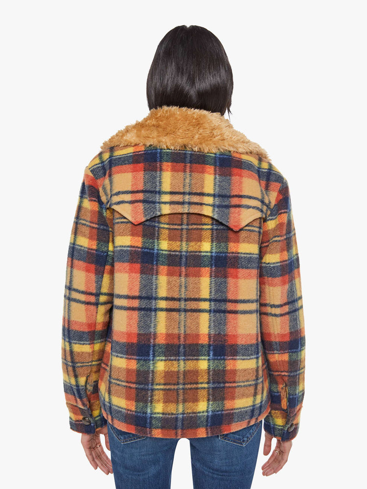 Back view of a woman in yellow, orange, and navy plaid boxy jacket with an oversized notched collar, buttons down the front and a loose fit.