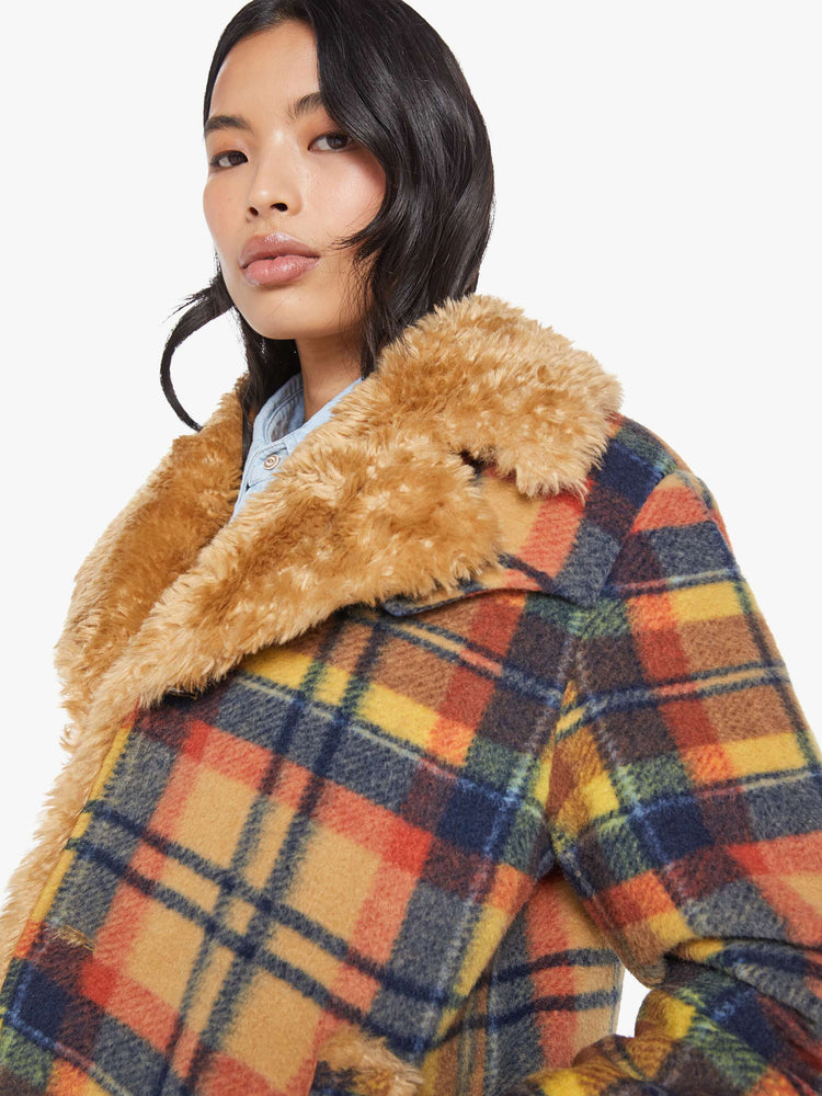 Close up view of a woman in yellow, orange, and navy plaid boxy jacket with an oversized notched collar, buttons down the front and a loose fit.