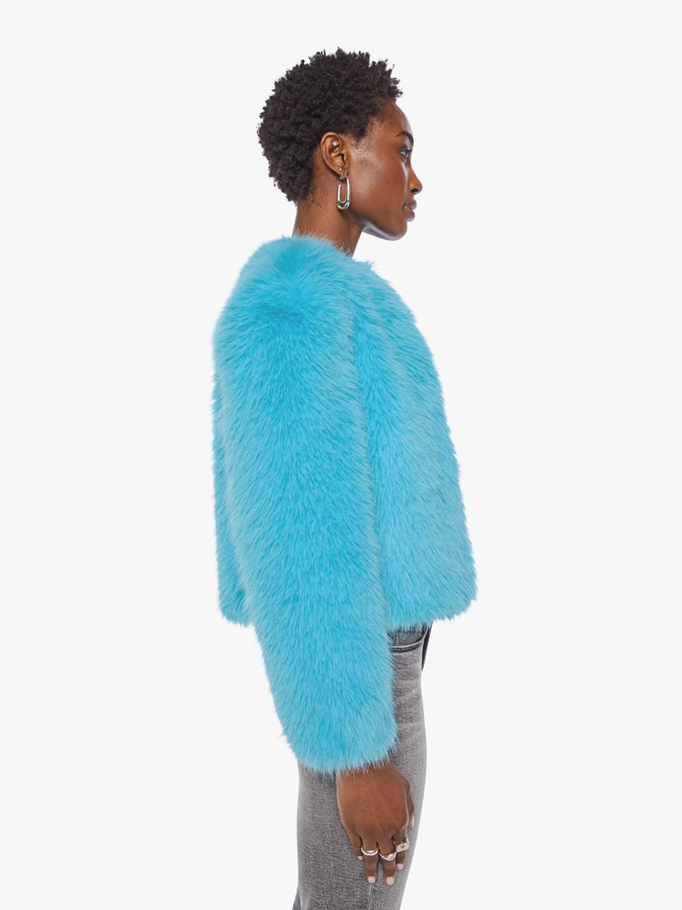 Side view of a woman in a bight light blue cropped jacket with a crewneck and boxy fit.