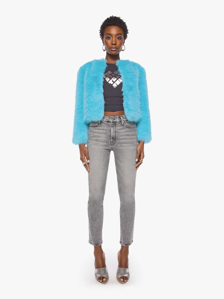 Full body view of a woman in a bight light blue cropped jacket with a crewneck and boxy fit.