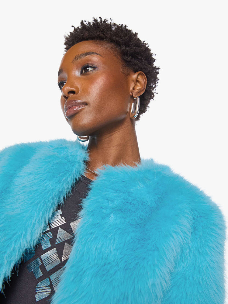 Close up view of a woman in a bight light blue cropped jacket with a crewneck and boxy fit.
