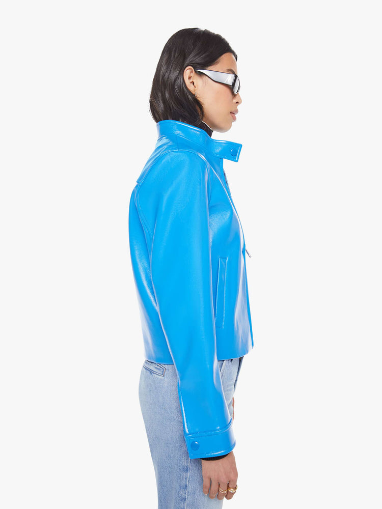 Side view of a baby blue moto-inspired zip-up jacket with a short stacked collar, slit pockets and a slightly narrow fit.