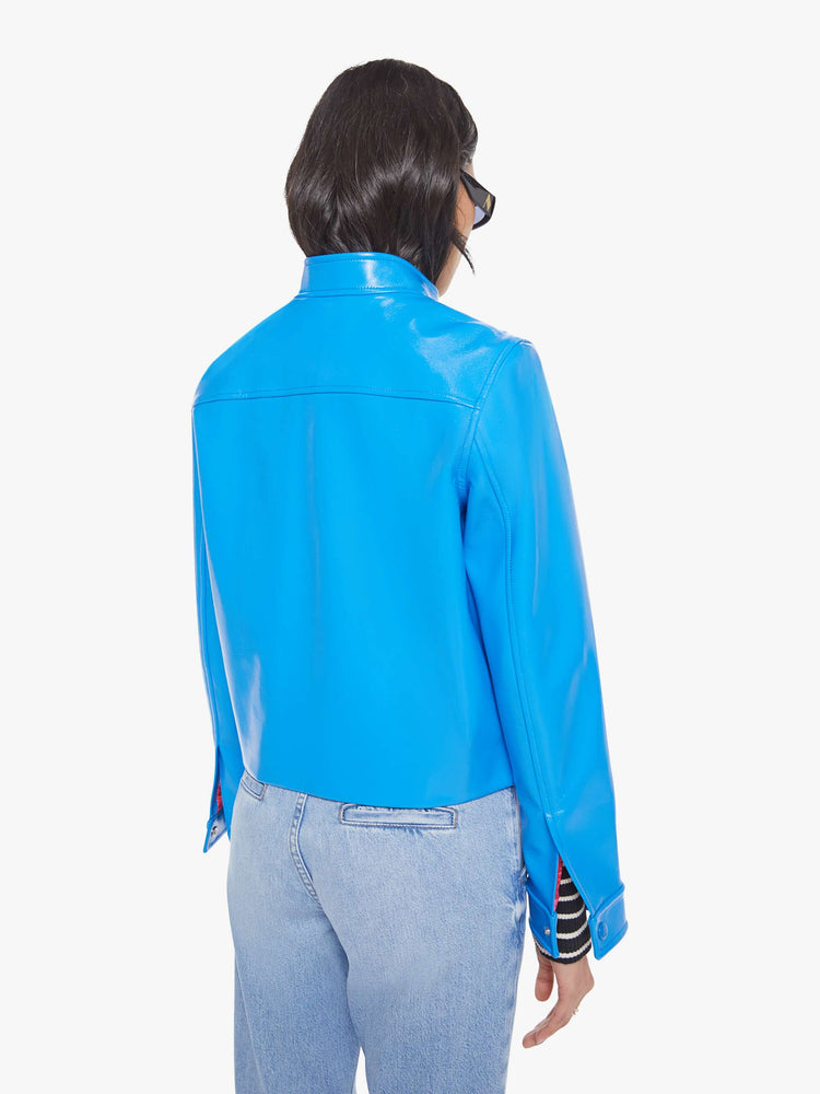 Back view of a baby blue moto-inspired zip-up jacket with a short stacked collar, slit pockets and a slightly narrow fit.