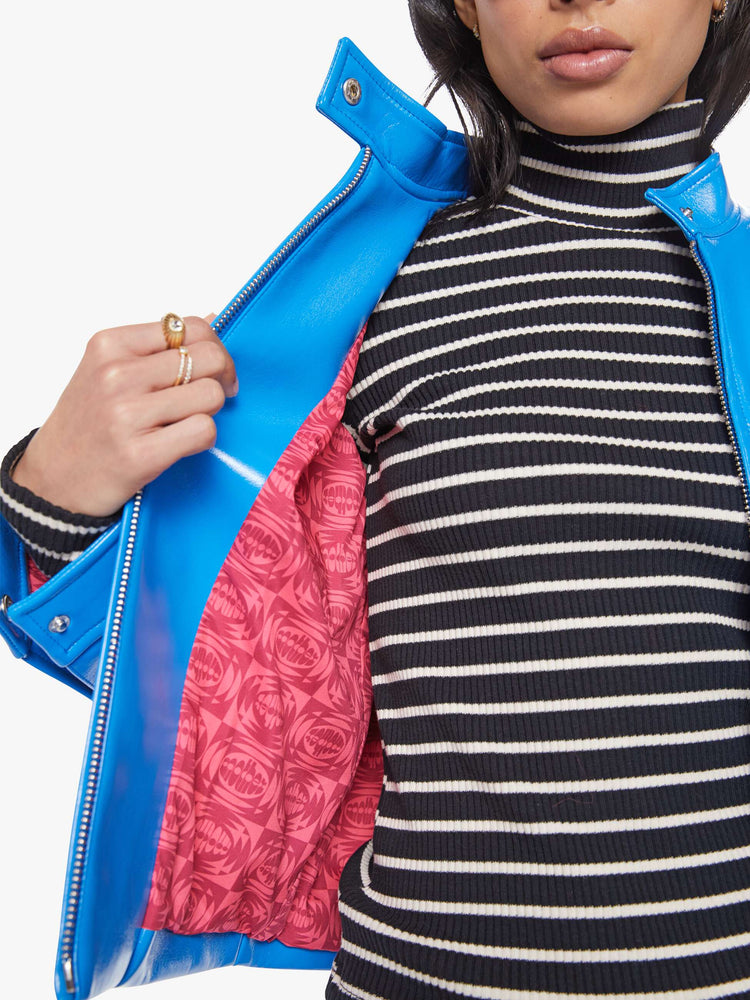 Inside lining view of a baby blue moto-inspired zip-up jacket with a short stacked collar, slit pockets and a slightly narrow fit.