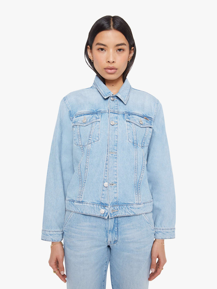 Front view of a woman in a light blue denim jacket with front patch pockets and a slightly cropped fit.