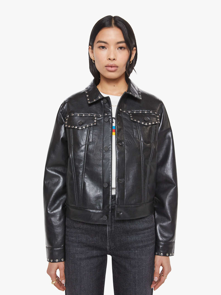 Front view of a woman in a black faux leather  classic button-up jacket with front patch pockets, drop shoulders and a boxy fit. 