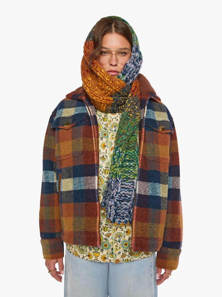 Front view of a woman in a brick red, navy, yellow and white plaid print with fuzzy faux-sherpa lining on the collared jacket with front patch pockets, a zip closure, drop shoulders and an oversized fit.