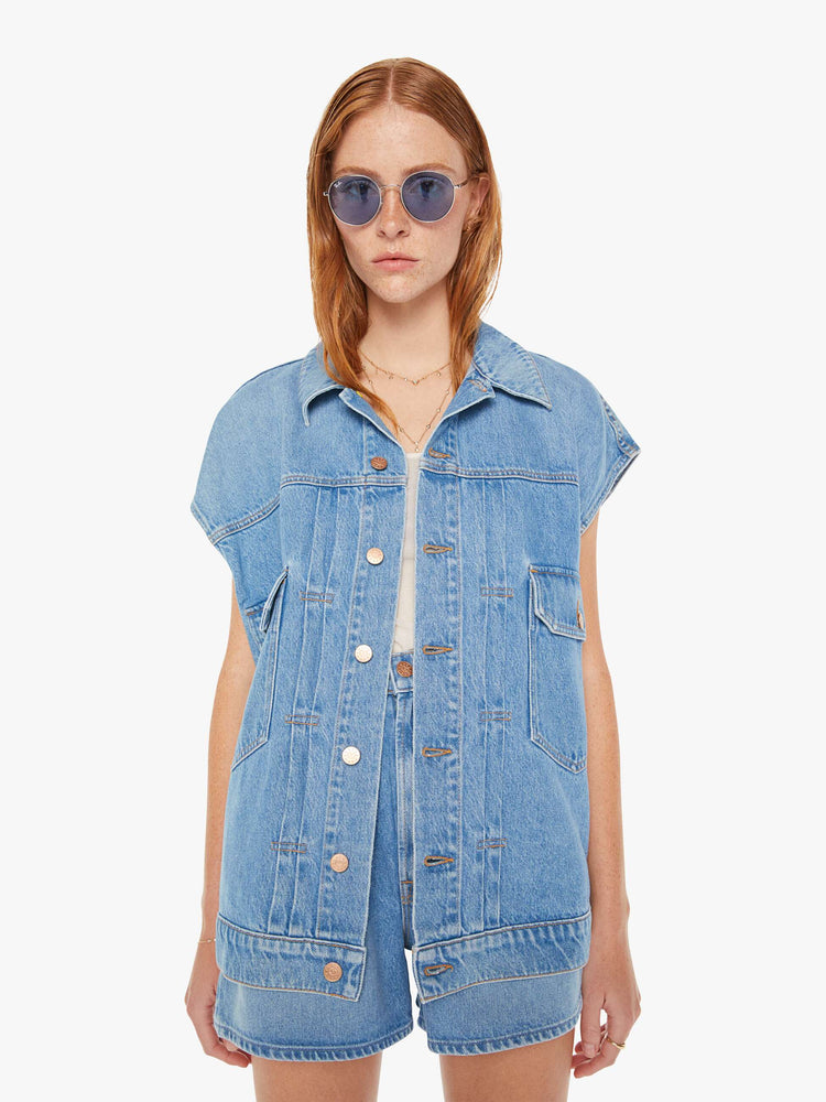 Front view of a womens light blue denim vest featuring an oversized fit.
