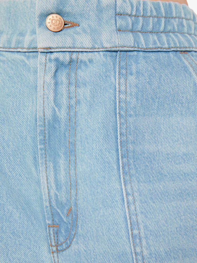 Close up swatch detail view of a light blue wash jean featuring contrast brown thread and an elastic waist.