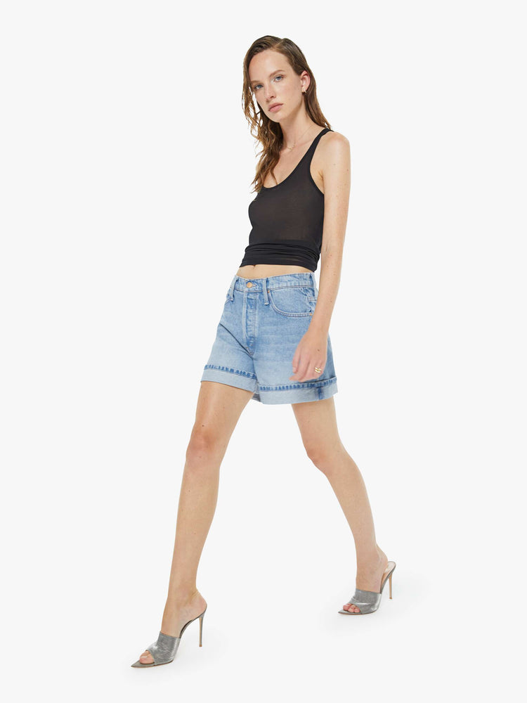 Walking view of a woman in a light blue shorts have a relaxed fit, button fly and a 4-inch inseam with a cuffed hem.