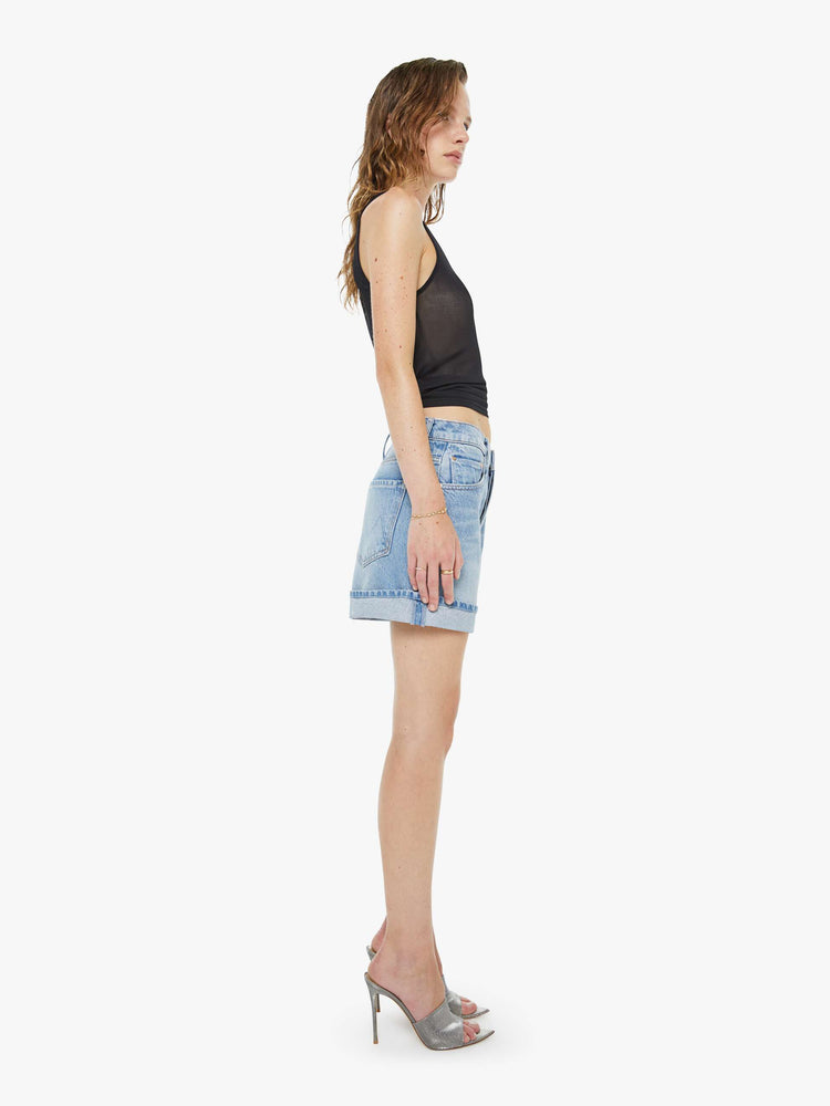 Side view of a woman in a light blue shorts have a relaxed fit, button fly and a 4-inch inseam with a cuffed hem.
