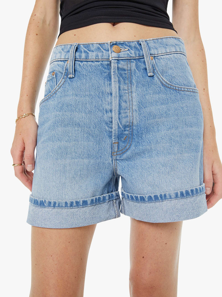 Close up view of a woman in a light blue shorts have a relaxed fit, button fly and a 4-inch inseam with a cuffed hem.
