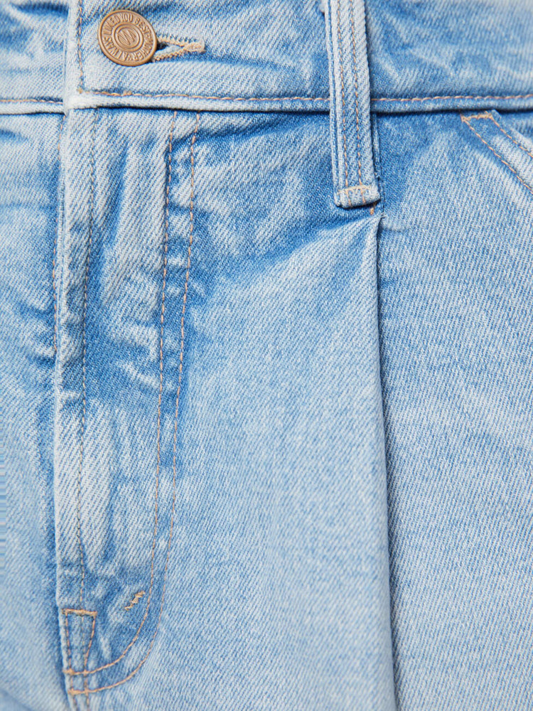 Swatch view of a woman in a light blue high-waisted denim shorts with a zip fly, slit pockets, pleats at the waistband and a 3-inch inseam with a clean hem.