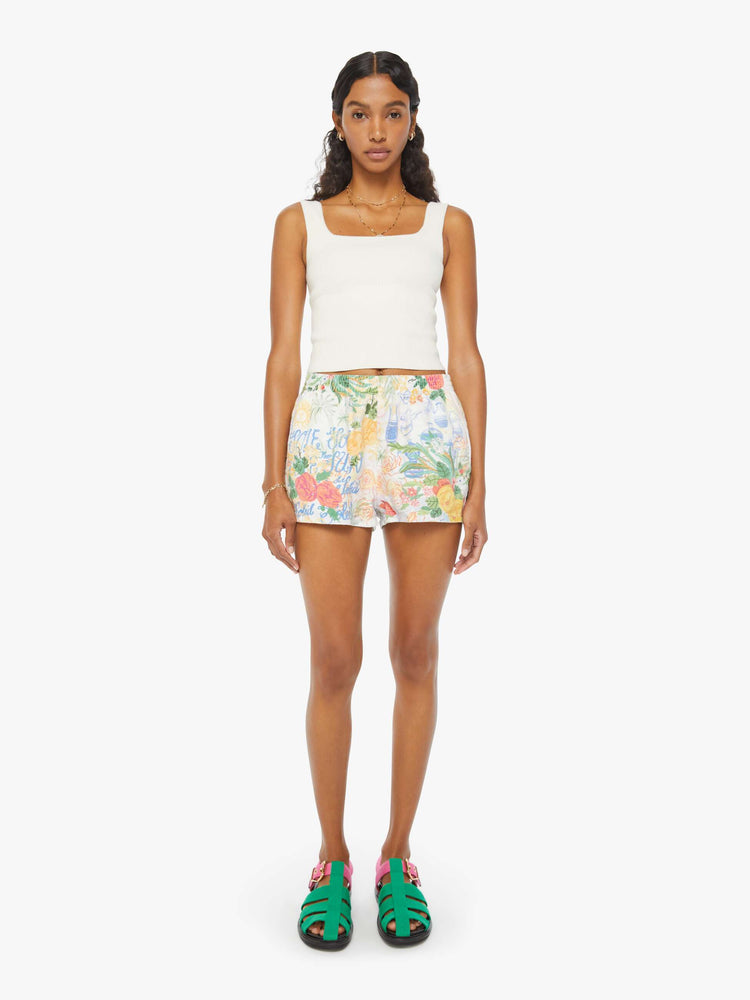 Front view of a woman in white high waisted pull on shorts with floral print.