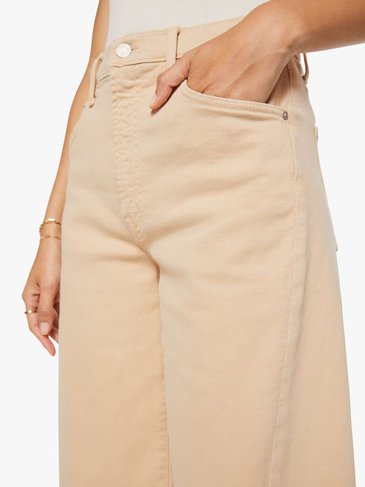Close up view of a woman in a khaki super high-waisted shorts with a wide leg, zip fly, calf-length inseam and a clean hem.