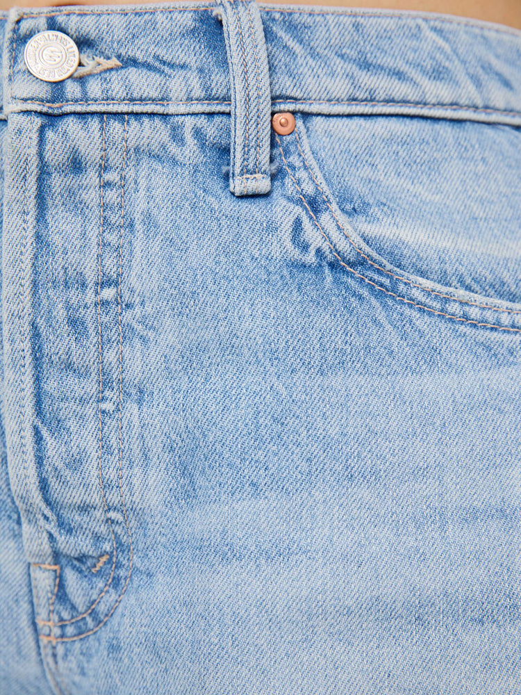 Swatch view of a woman in a light blue super high-waisted denim shorts with a zip fly, 4.75-inch inseam, a frayed hem and a low-slung fit.